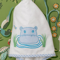 White hooded towel with blue hippo design hanging against a colorful floral and nature-themed background, 3 Marthas