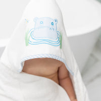 Child wrapped in hooded towel featuring a blue hippo applique sitting by the tub, 3 Marthas