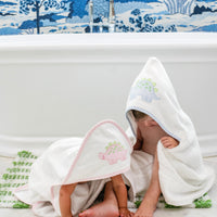 3 Marthas white terrycloth hooded towel with pink dino applique and pink trim for girls. White terrycloth hooded towel with blue dino applique and blue trim for boys.