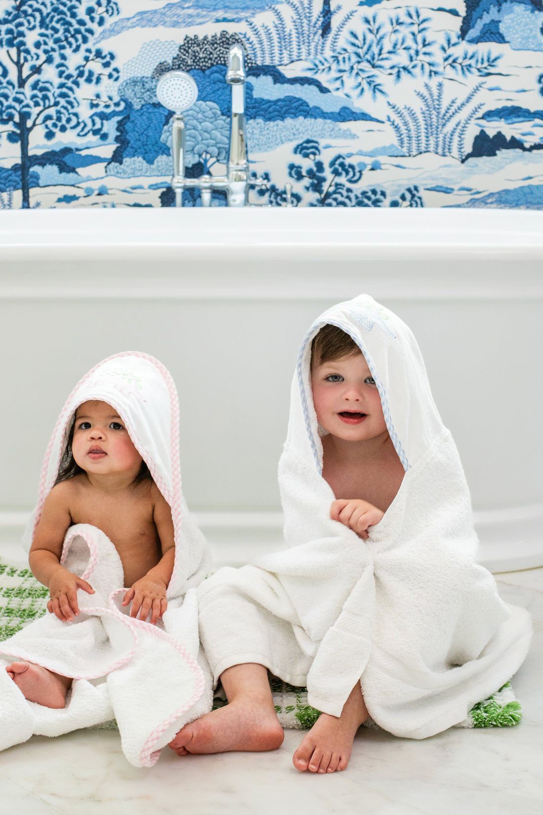 3 Marthas white terrycloth hooded towel with pink dino applique and pink trim for girls. White terrycloth hooded towel with blue dino applique and blue trim for boys.
