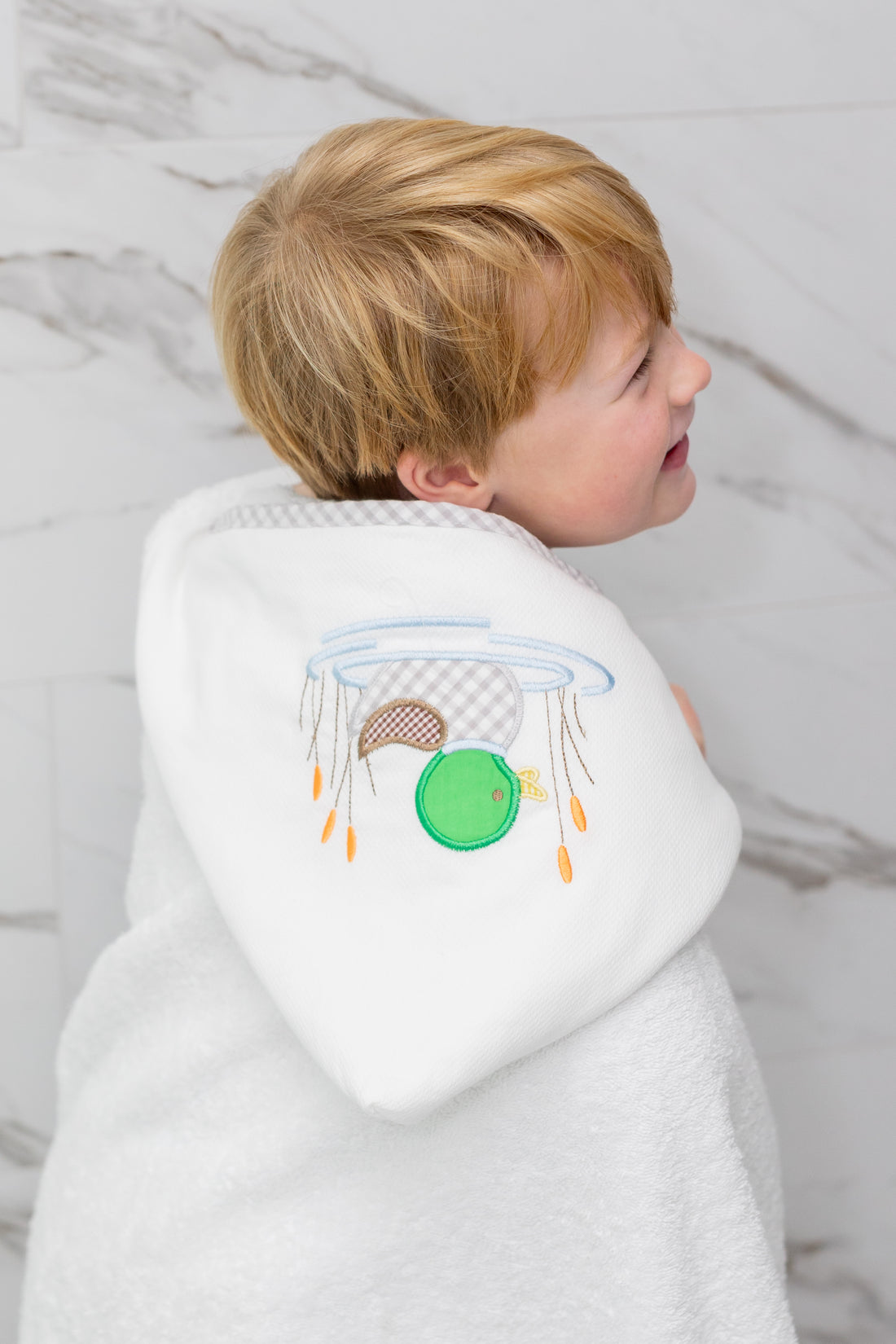 Child wrapped in mallard hooded towel, 3 Marthas