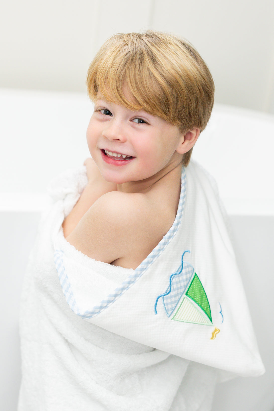 Child wrapped in bath towel featuring sailboat, 3 Marthas
