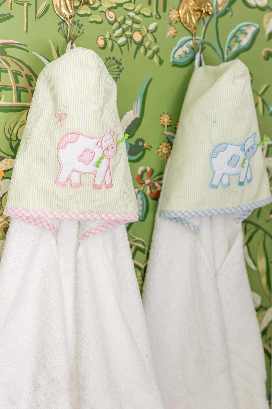 Handing hooded towels for children featuring blue and pink cow applique, 3 Marthas