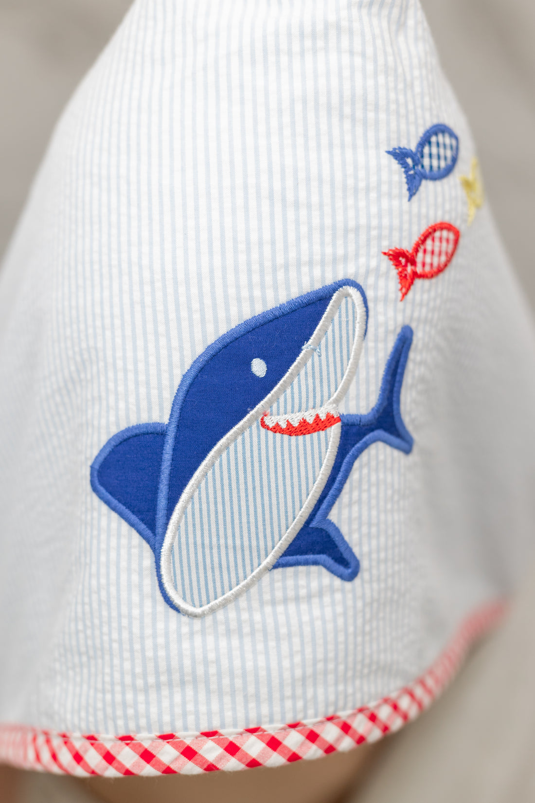 Child wearing a white hooded towel with a blue shark design, 3 Marthas