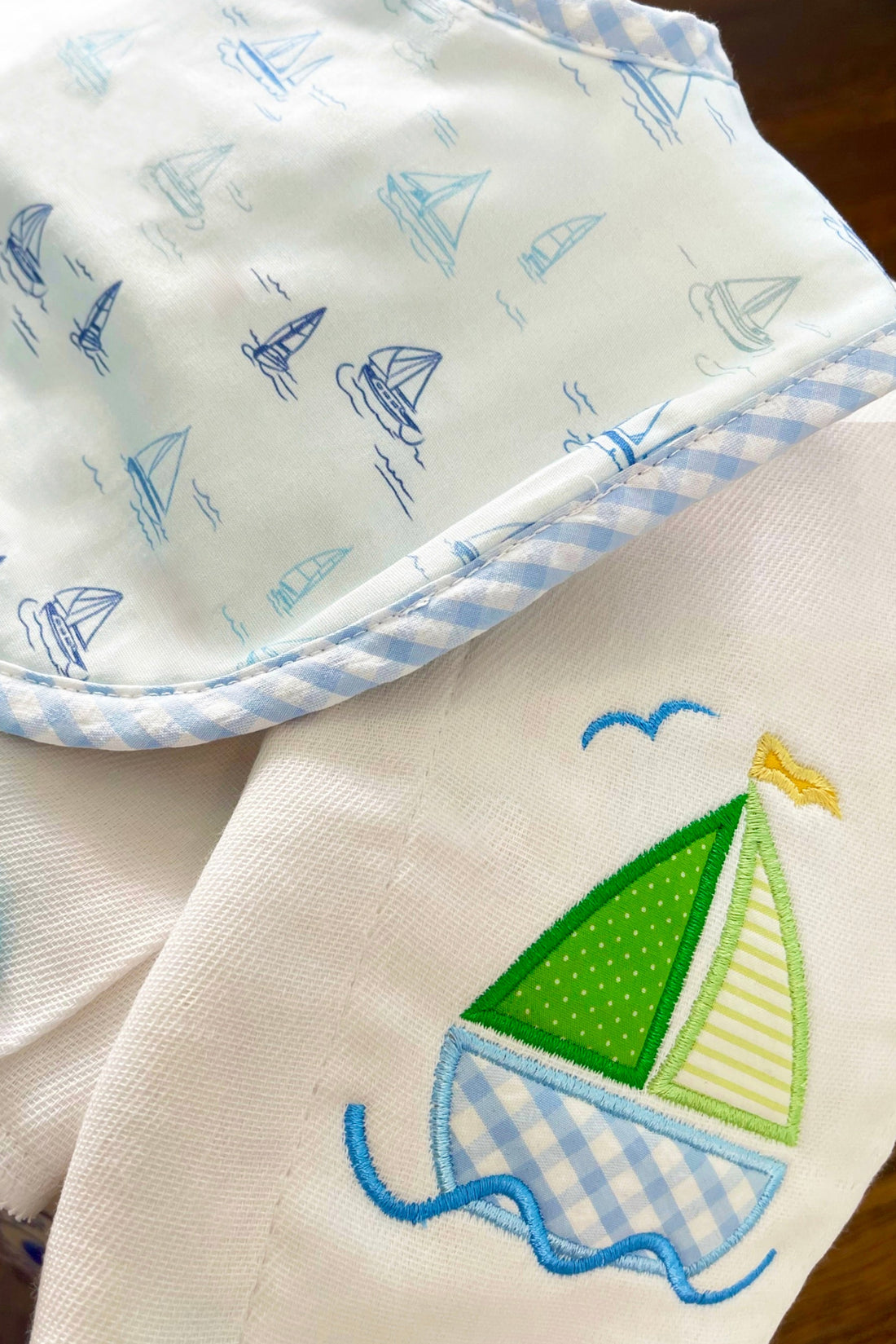 Cotton bib for baby boy with blue sailboat print fabric and blue gingham check trim and burp cloth with green sailboat applique, 3 Marthas