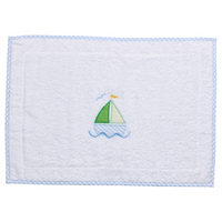 White terry bath mat with a blue sailboat applique