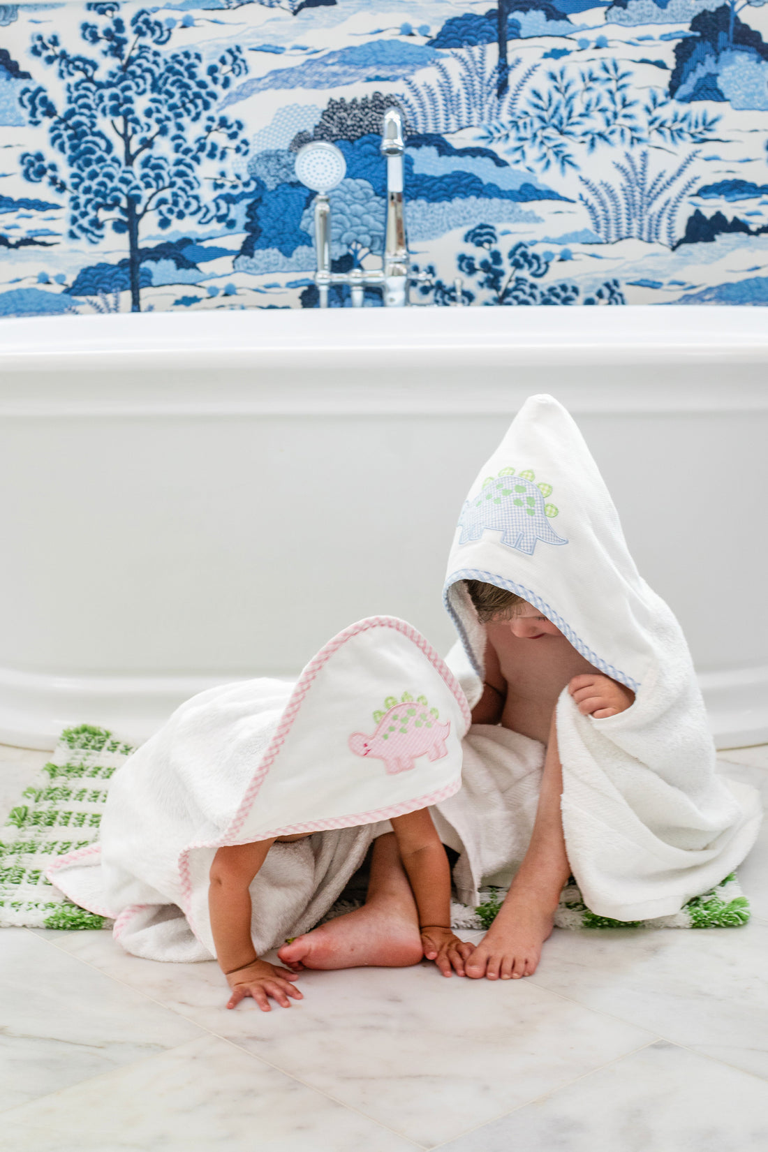 3 Marthas white terrycloth hooded towel with pink dino applique and pink trim for girls. White terrycloth hooded towel with blue dino applique and blue trim for boys. 